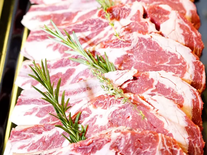 Raw beef steaks with rosemary on a board, representing farm meat shares